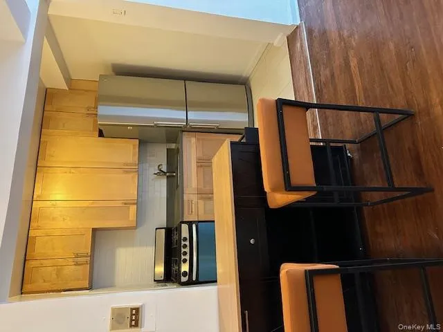 Kitchen featuring refrigerator, decorative backsplash, stainless steel range, dark wood-type flooring, and a breakfast bar Kitchen featuring refrigerator, decorative backsplash, stainless steel range, dark wood-type flooring, and a breakfast bar