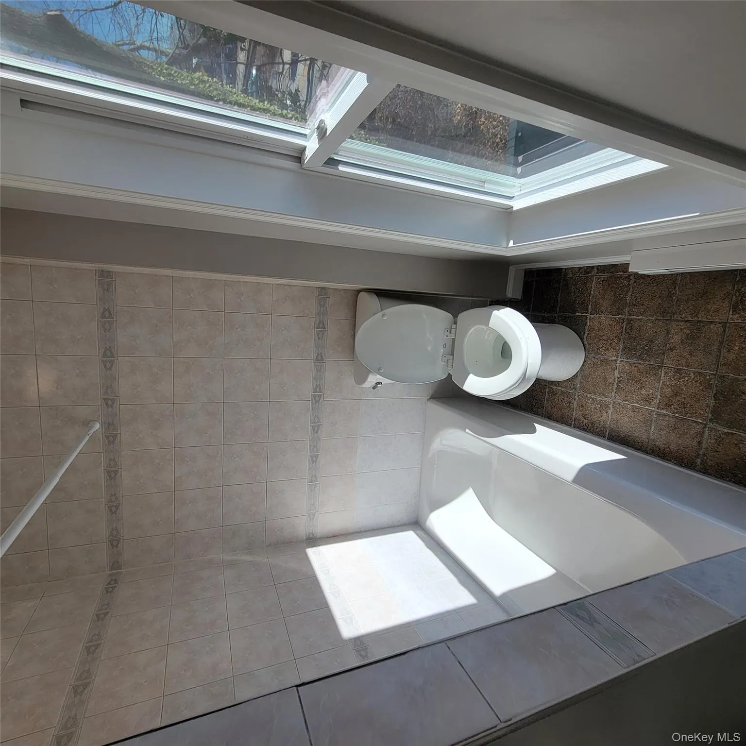 Full bathroom featuring toilet and bathing tub / shower combination Full bathroom featuring toilet and bathing tub / shower combination