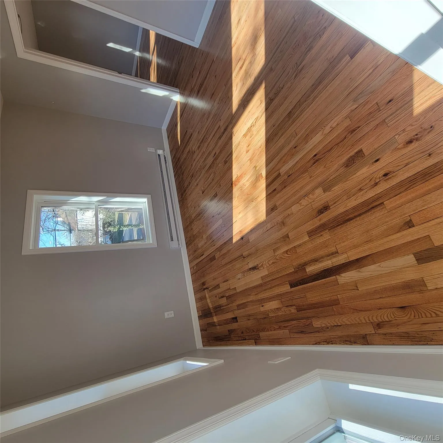 Spare room with hardwood / wood-style floors and baseboard heating Spare room with hardwood / wood-style floors and baseboard heating