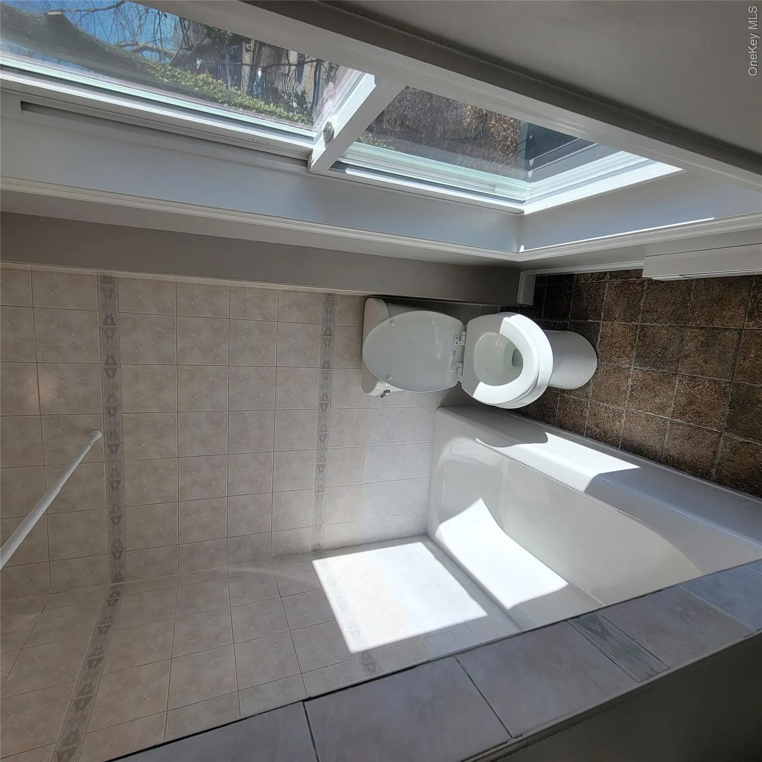 Full bathroom featuring toilet and bathing tub / shower combination Full bathroom featuring toilet and bathing tub / shower combination