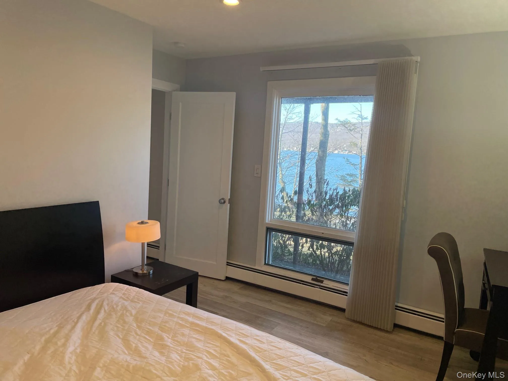 Bedroom with a baseboard heating unit, wood finished floors, and recessed lighting Bedroom with a baseboard heating unit, wood finished floors, and recessed lighting