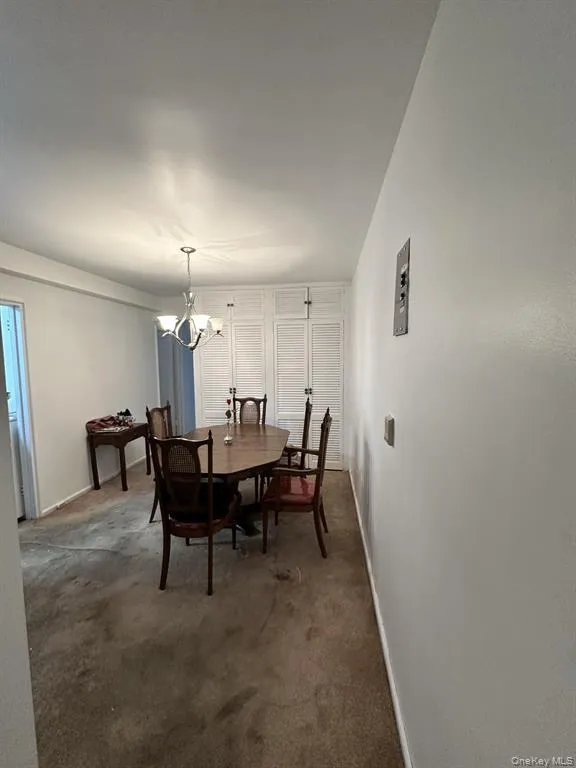Dining space featuring a chandelier and dark carpet Dining space featuring a chandelier and dark carpet