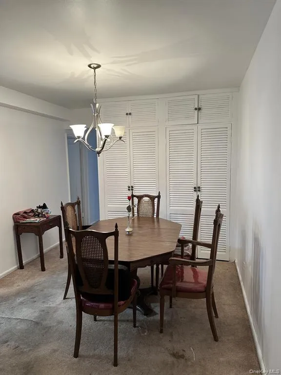 Dining space featuring carpet flooring and a chandelier Dining space featuring carpet flooring and a chandelier