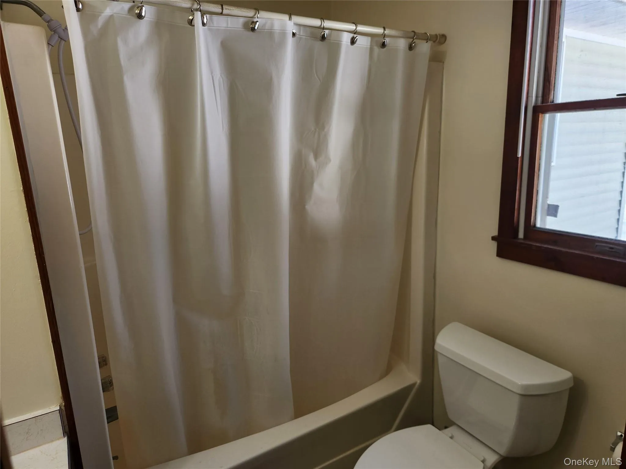 Full bath featuring toilet and shower / bath combo Full bath featuring toilet and shower / bath combo