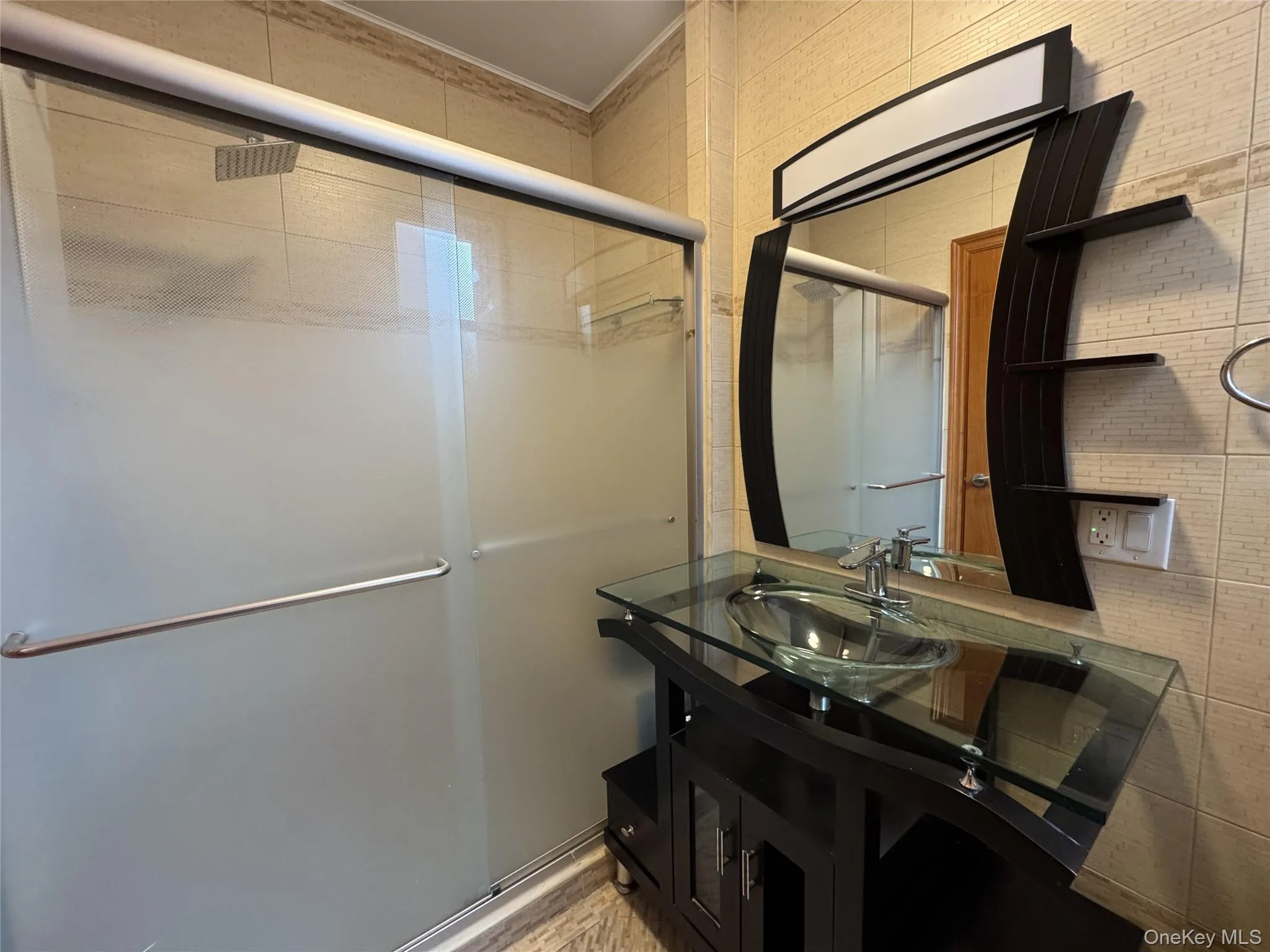 Bathroom featuring a shower stall and vanity Bathroom featuring a shower stall and vanity