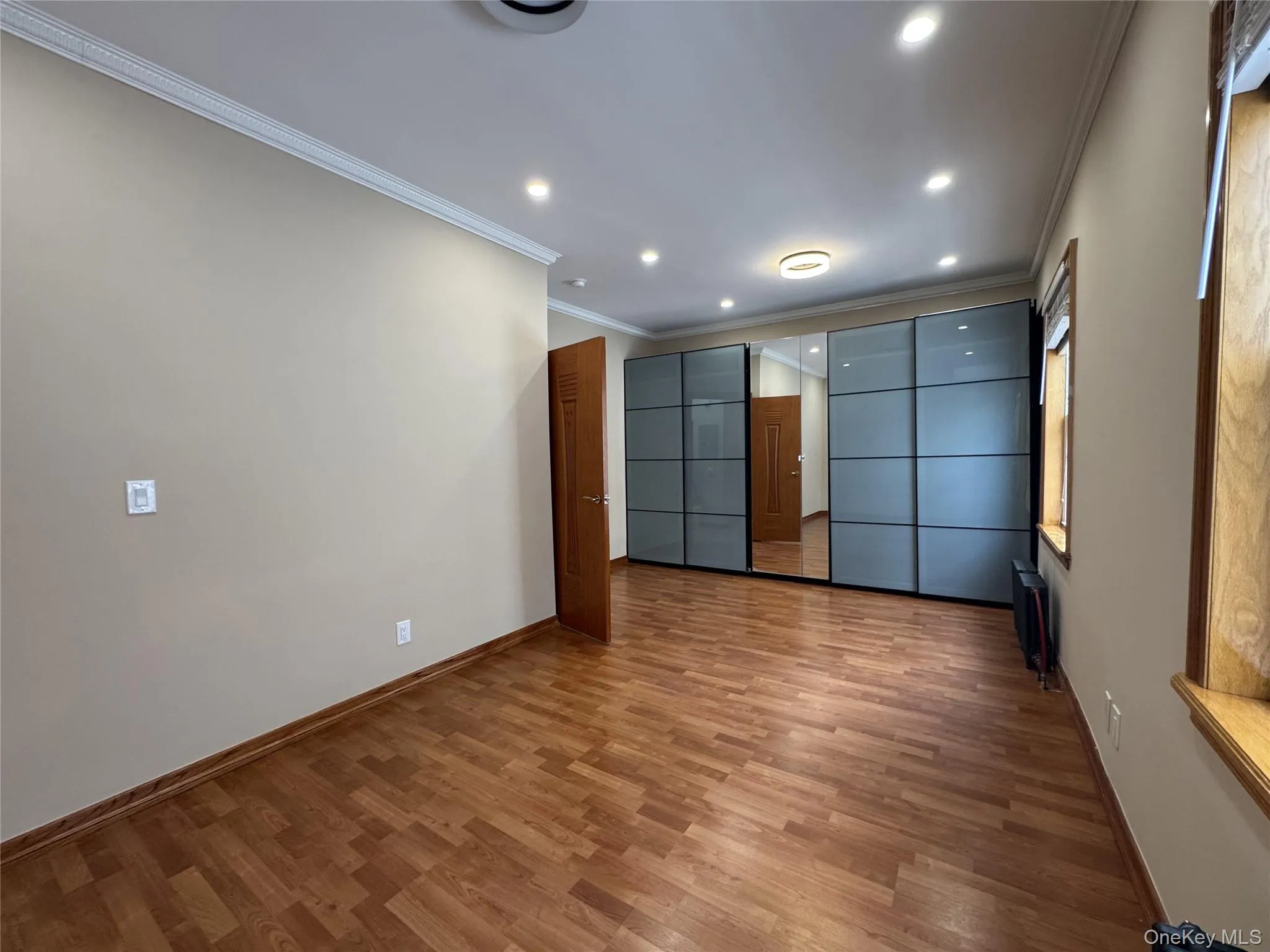 Unfurnished room with crown molding, wood finished floors, and recessed lighting Unfurnished room with crown molding, wood finished floors, and recessed lighting