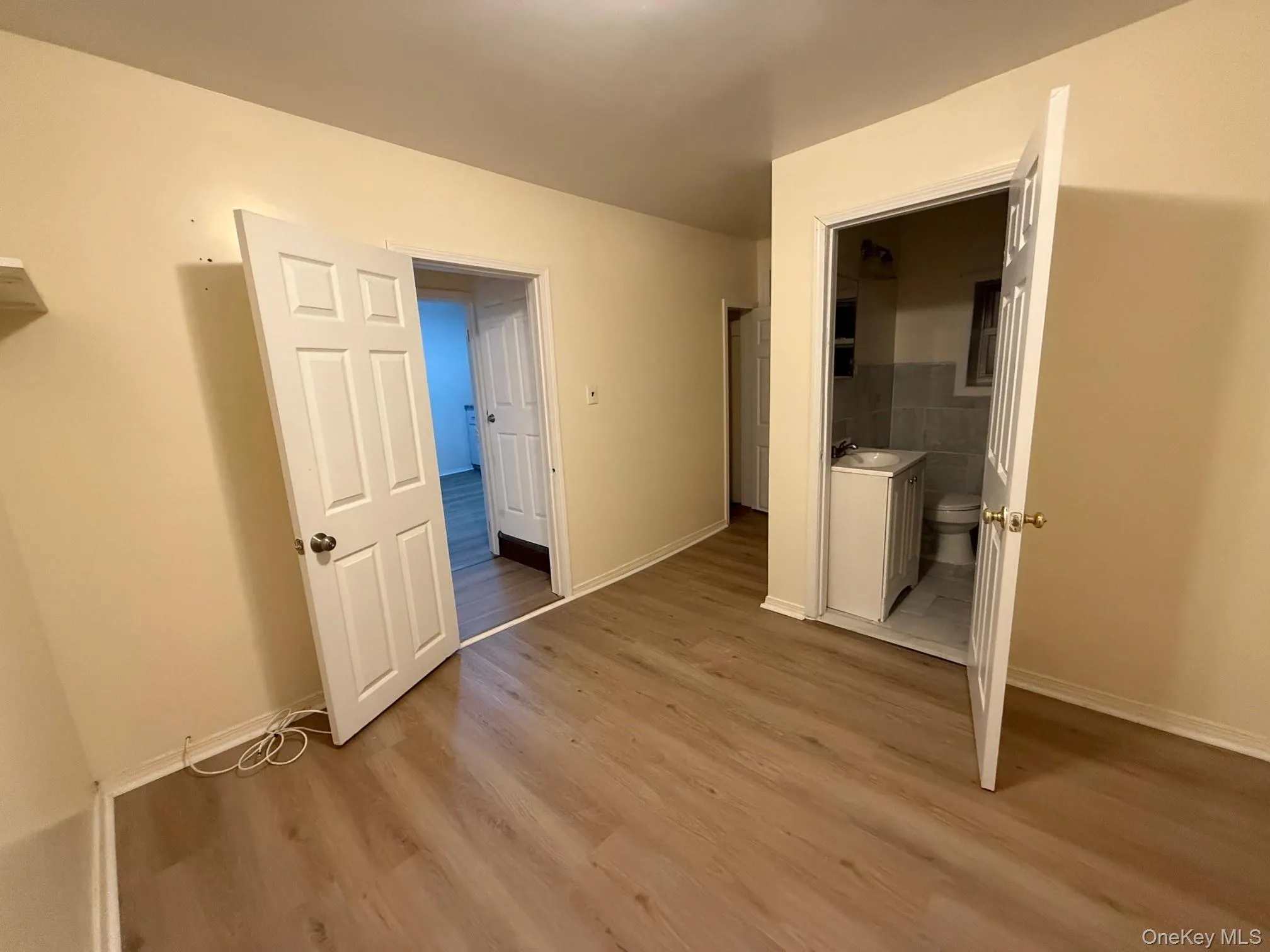 Unfurnished bedroom with light wood-style floors and connected bathroom Unfurnished bedroom with light wood-style floors and connected bathroom