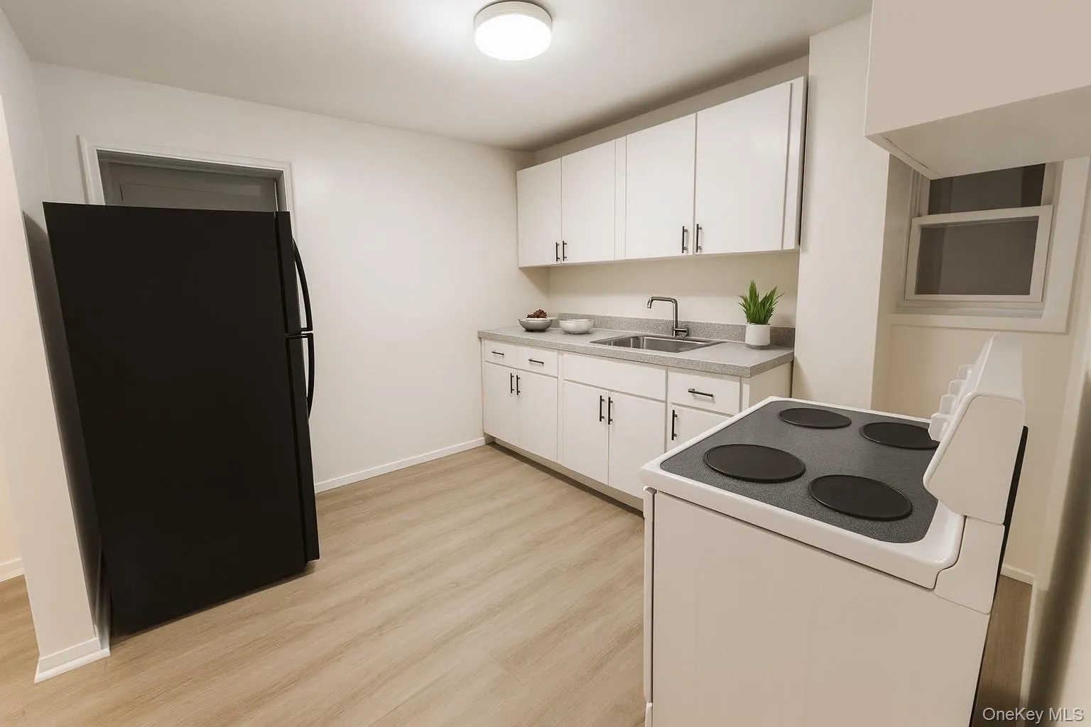 Kitchen featuring freestanding refrigerator, white electric range oven, white cabinets, and light countertops Kitchen featuring freestanding refrigerator, white electric range oven, white cabinets, and light countertops