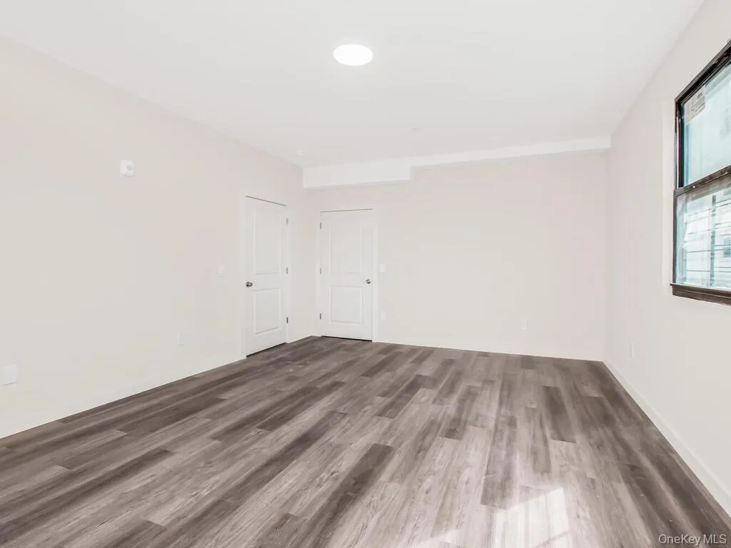 Empty room with wood finished floors and recessed lighting Empty room with wood finished floors and recessed lighting