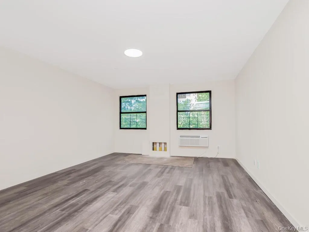 Spare room with wood finished floors and a wall unit AC Spare room with wood finished floors and a wall unit AC