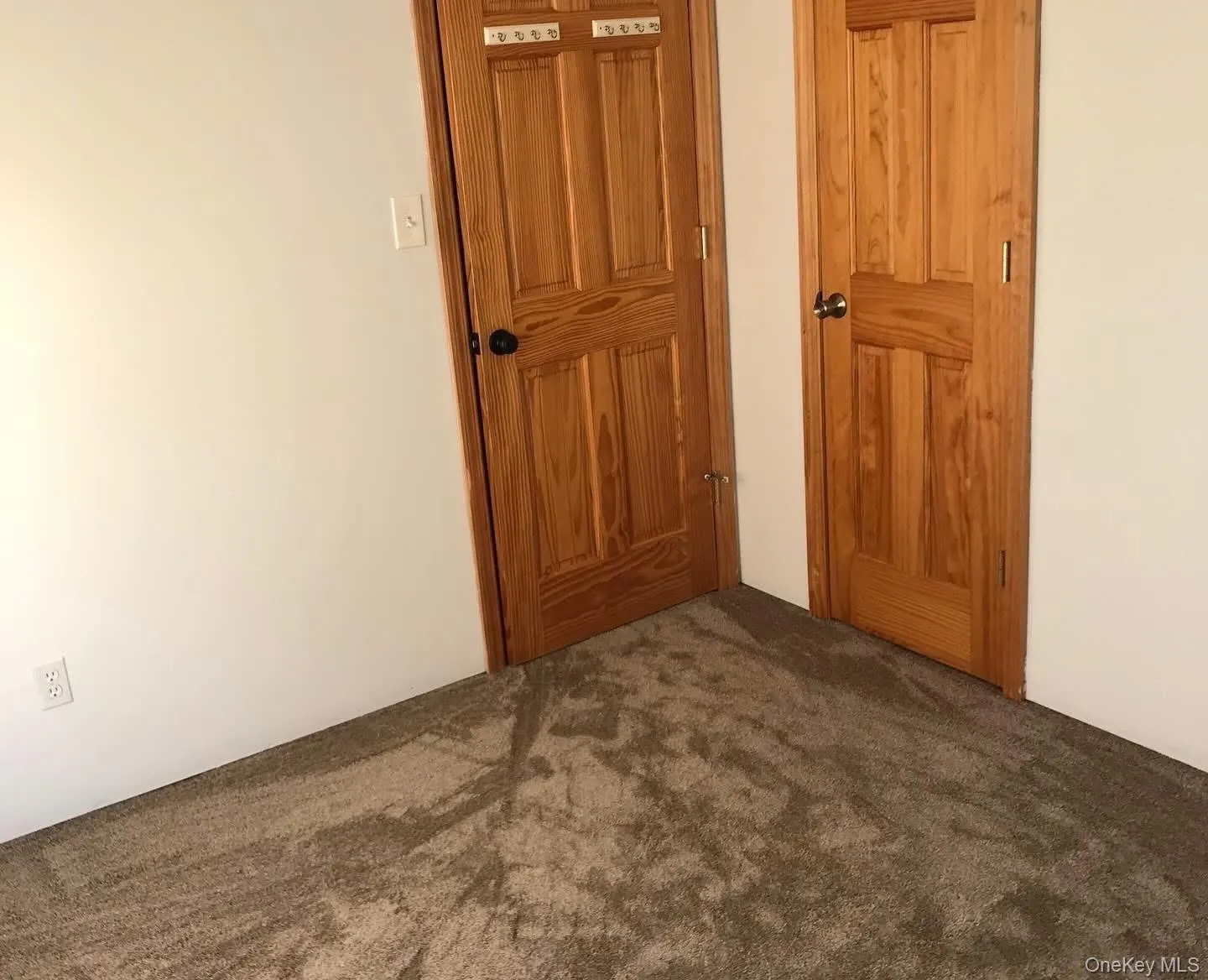 Unfurnished bedroom featuring dark carpet Unfurnished bedroom featuring dark carpet