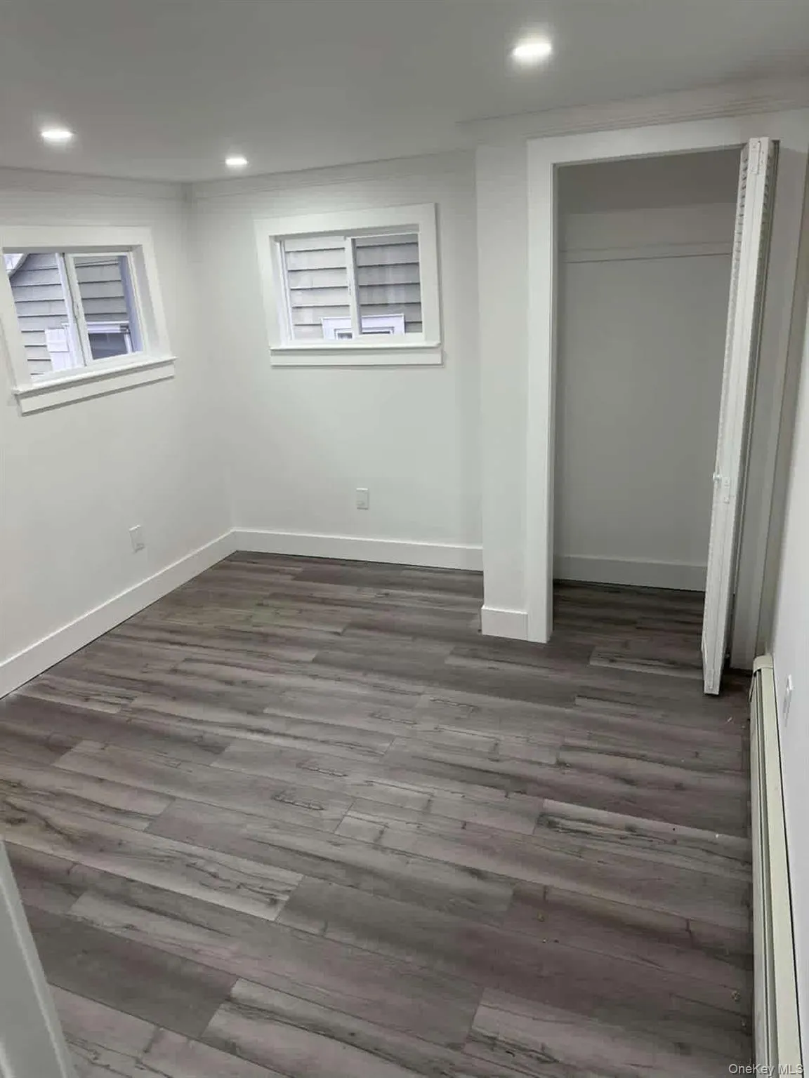 dark wood-style floors, and a baseboard heating unit dark wood-style floors, and a baseboard heating unit