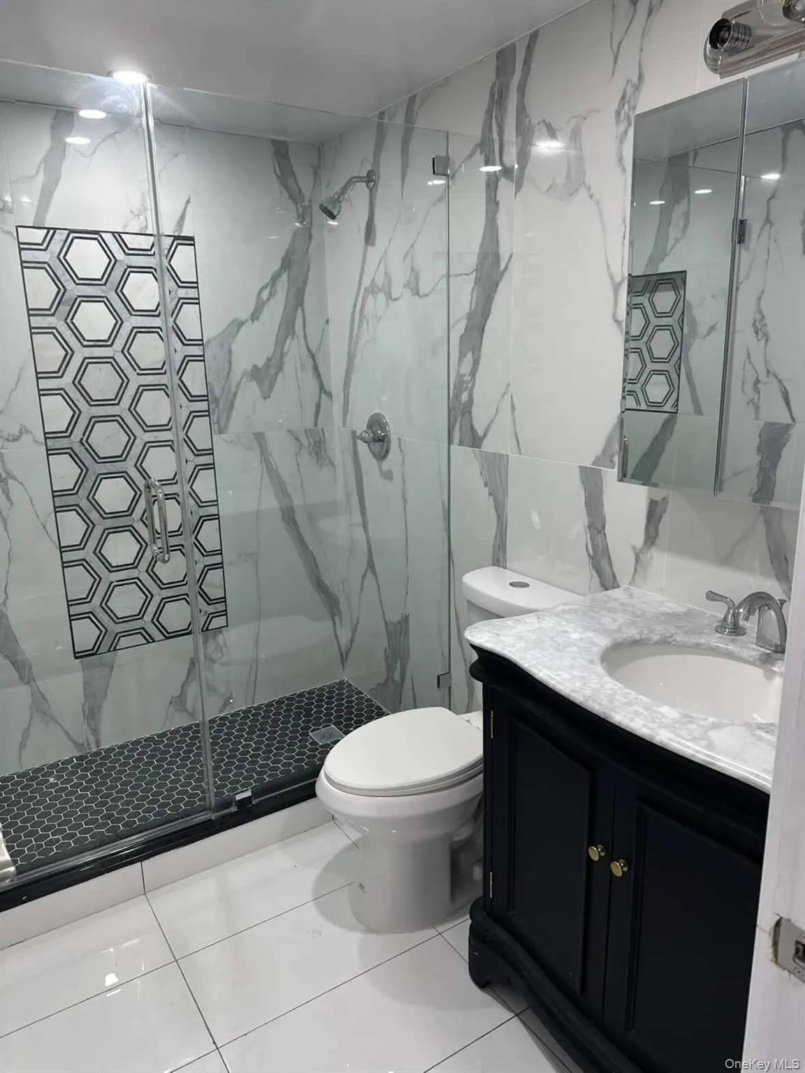 Master Full bath with tile walls, vanity, and a marble finish shower Master Full bath with tile walls, vanity, and a marble finish shower