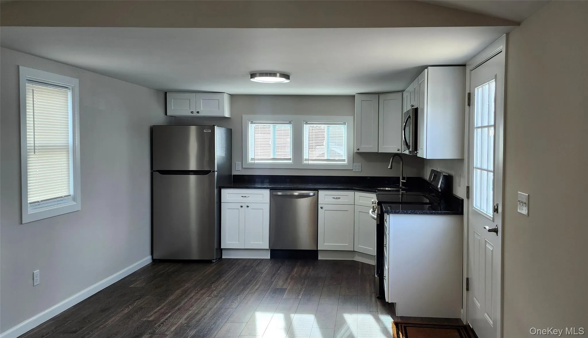 NEW Kitchen featuring white cabinetry, quartz counter tops, Stainless Steel appliances with new vinyl floors NEW Kitchen featuring white cabinetry, quartz counter tops, Stainless Steel appliances with new vinyl floors