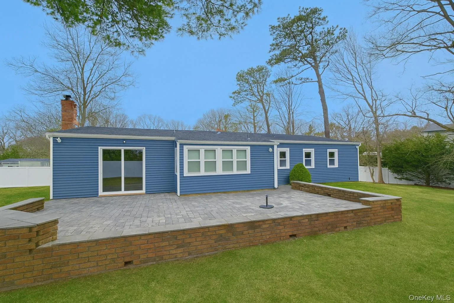 Rear view of house with a patio area and a chimney Rear view of house with a patio area and a chimney
