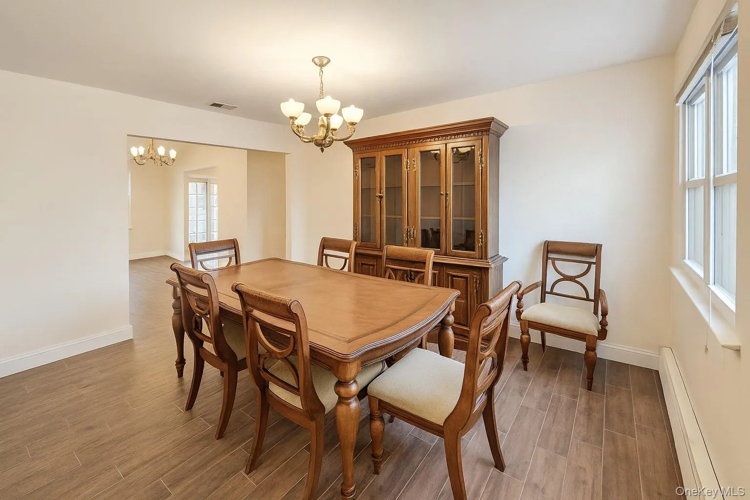 Dining area featuring a baseboard heating unit, wood tiled floors, and a chandelier Dining area featuring a baseboard heating unit, wood tiled floors, and a chandelier