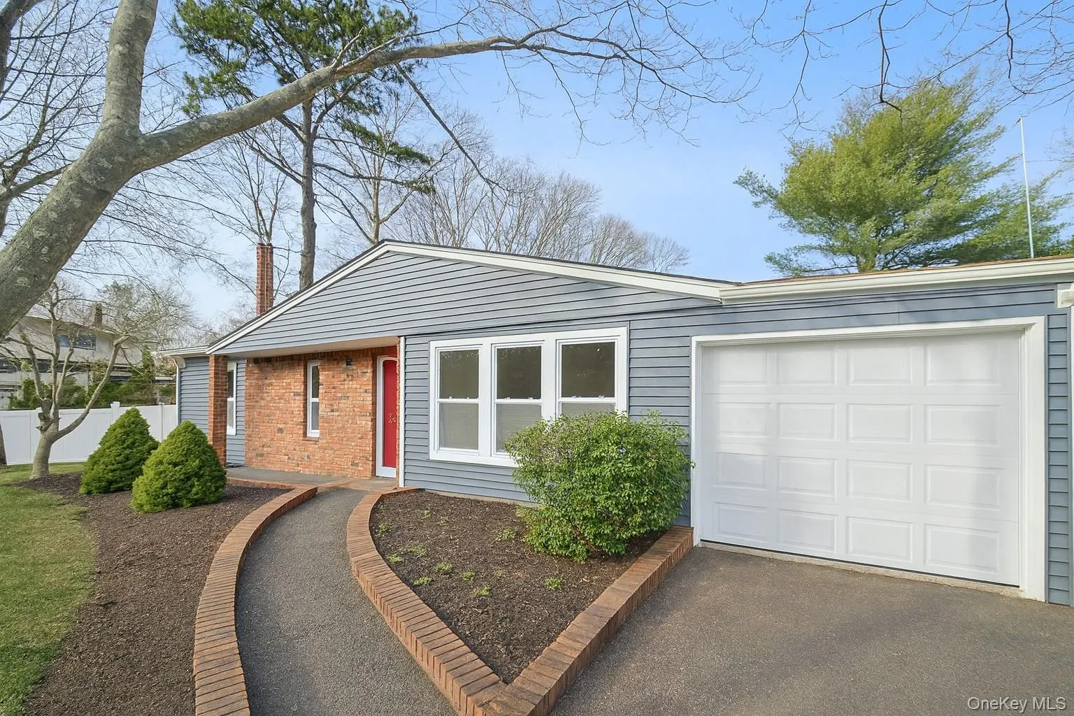 View of front facade with an attached garage, a chimney, asphalt driveway, and brick siding View of front facade with an attached garage, a chimney, asphalt driveway, and brick siding