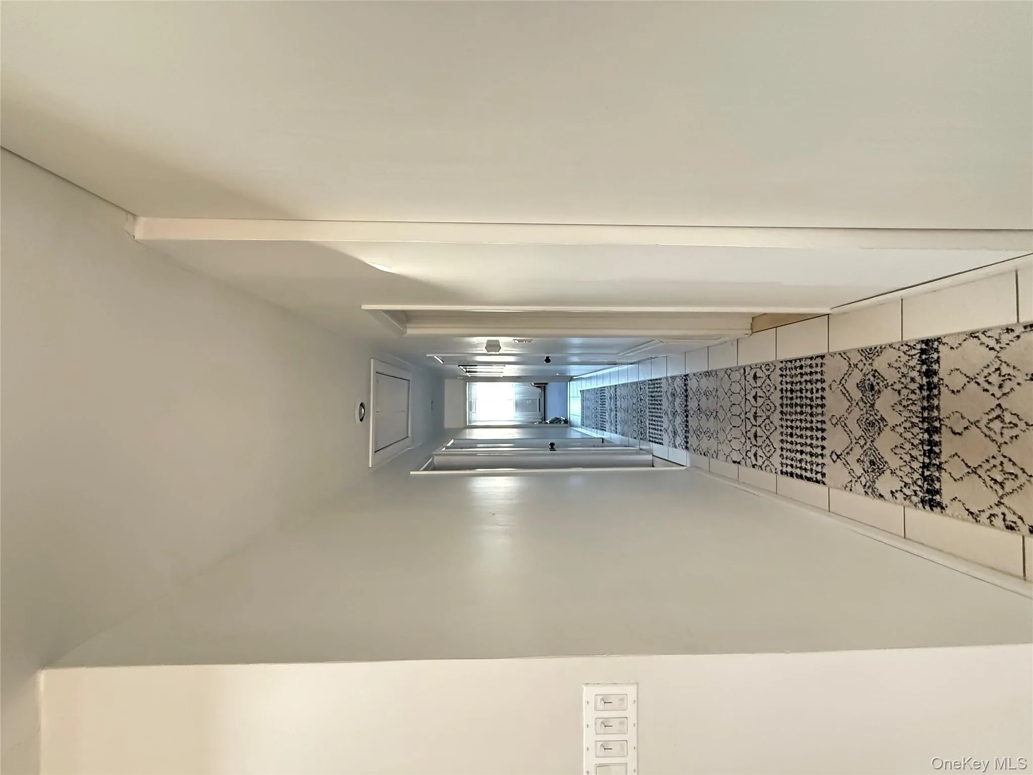 Hallway with attic access and light tile patterned flooring Hallway with attic access and light tile patterned flooring