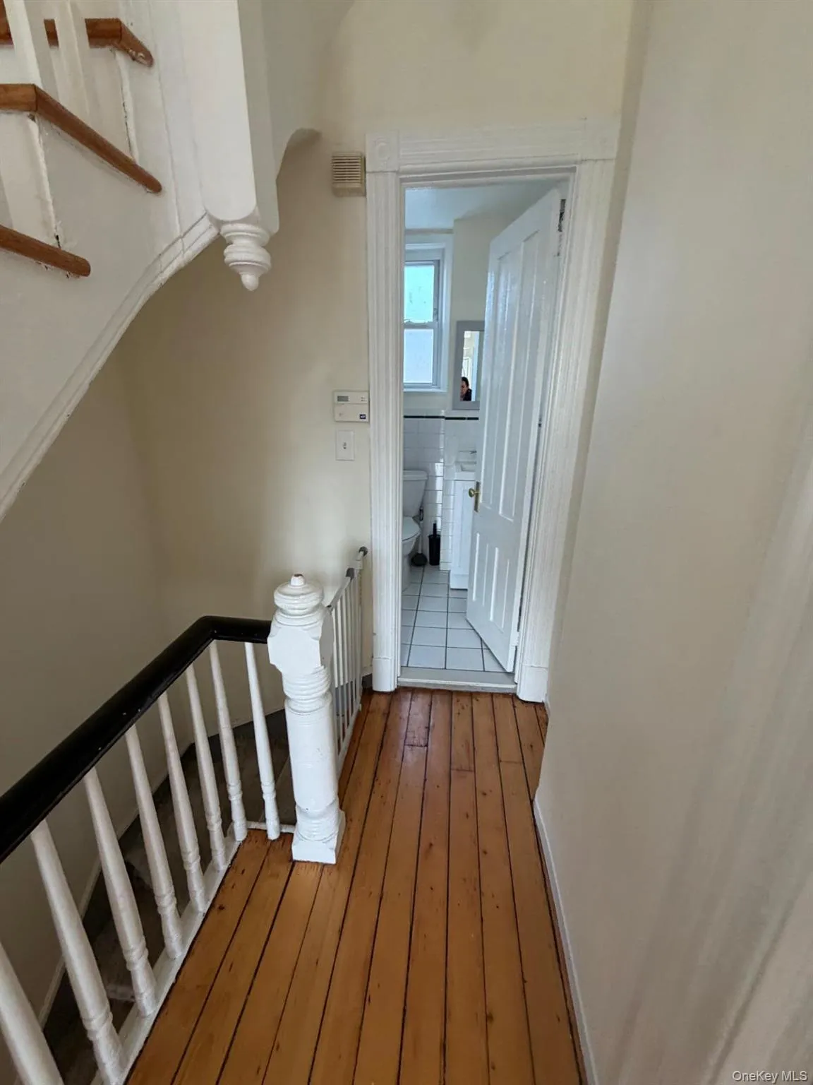 Staircase featuring hardwood / wood-style flooring and baseboards Staircase featuring hardwood / wood-style flooring and baseboards
