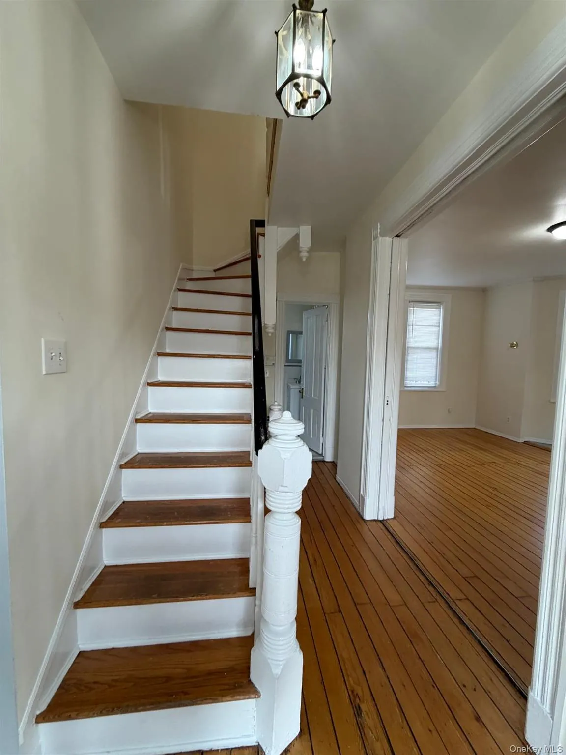 Stairway featuring hardwood / wood-style floors and a chandelier Stairway featuring hardwood / wood-style floors and a chandelier
