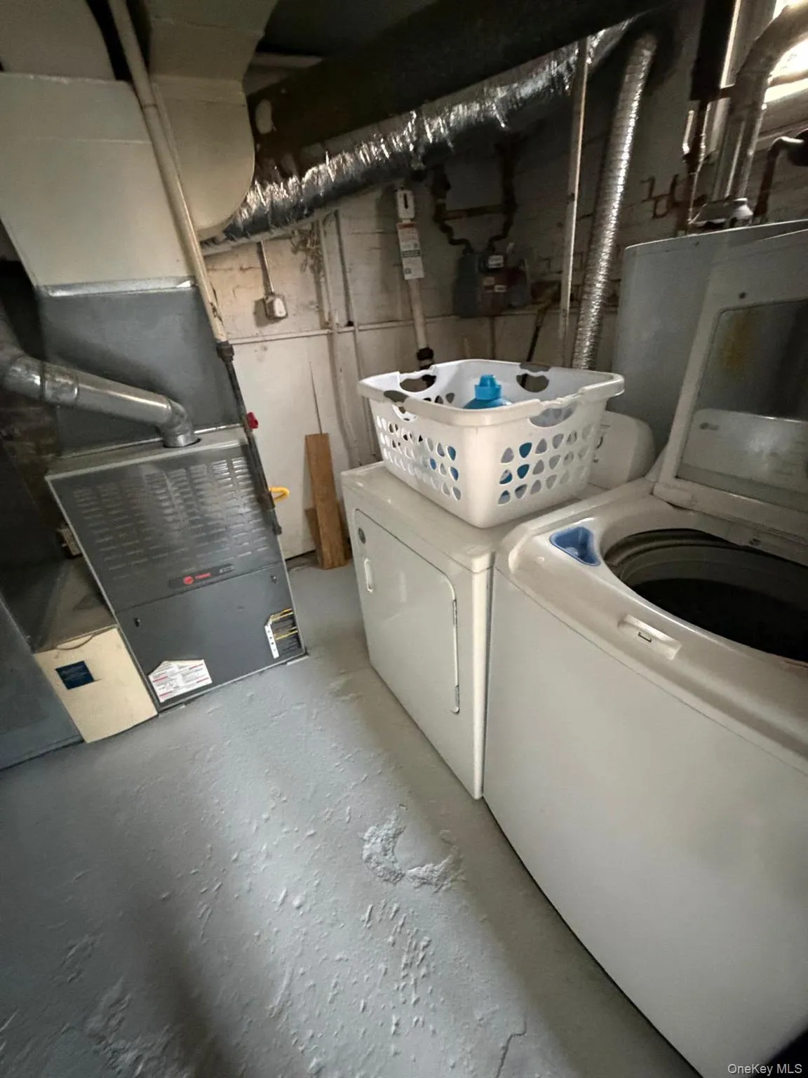 Laundry room with heating unit, concrete flooring, and washer and clothes dryer Laundry room with heating unit, concrete flooring, and washer and clothes dryer