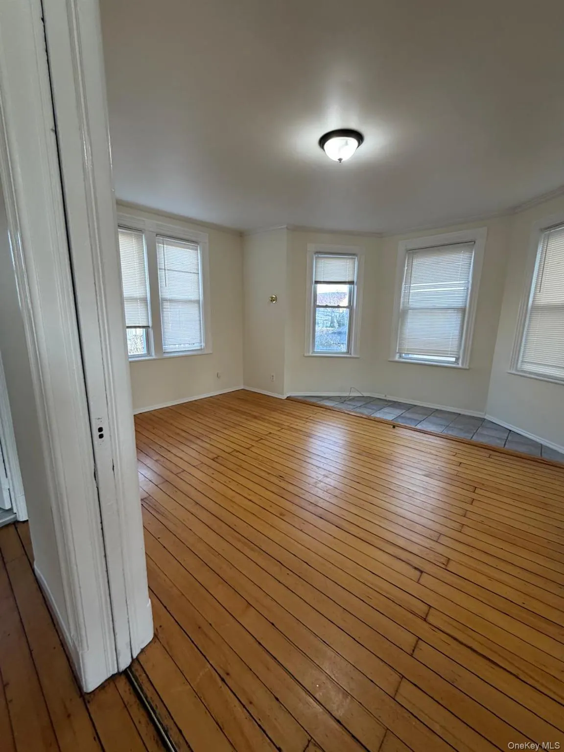 Unfurnished room featuring wood-type flooring and baseboards Unfurnished room featuring wood-type flooring and baseboards