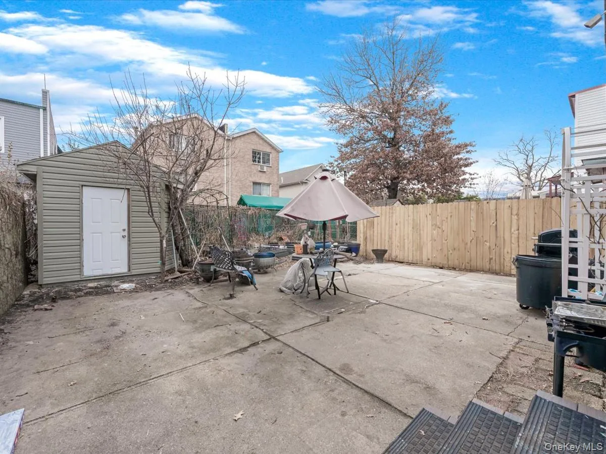 Fenced backyard with a patio, an outdoor fire pit, and a storage shed Fenced backyard with a patio, an outdoor fire pit, and a storage shed