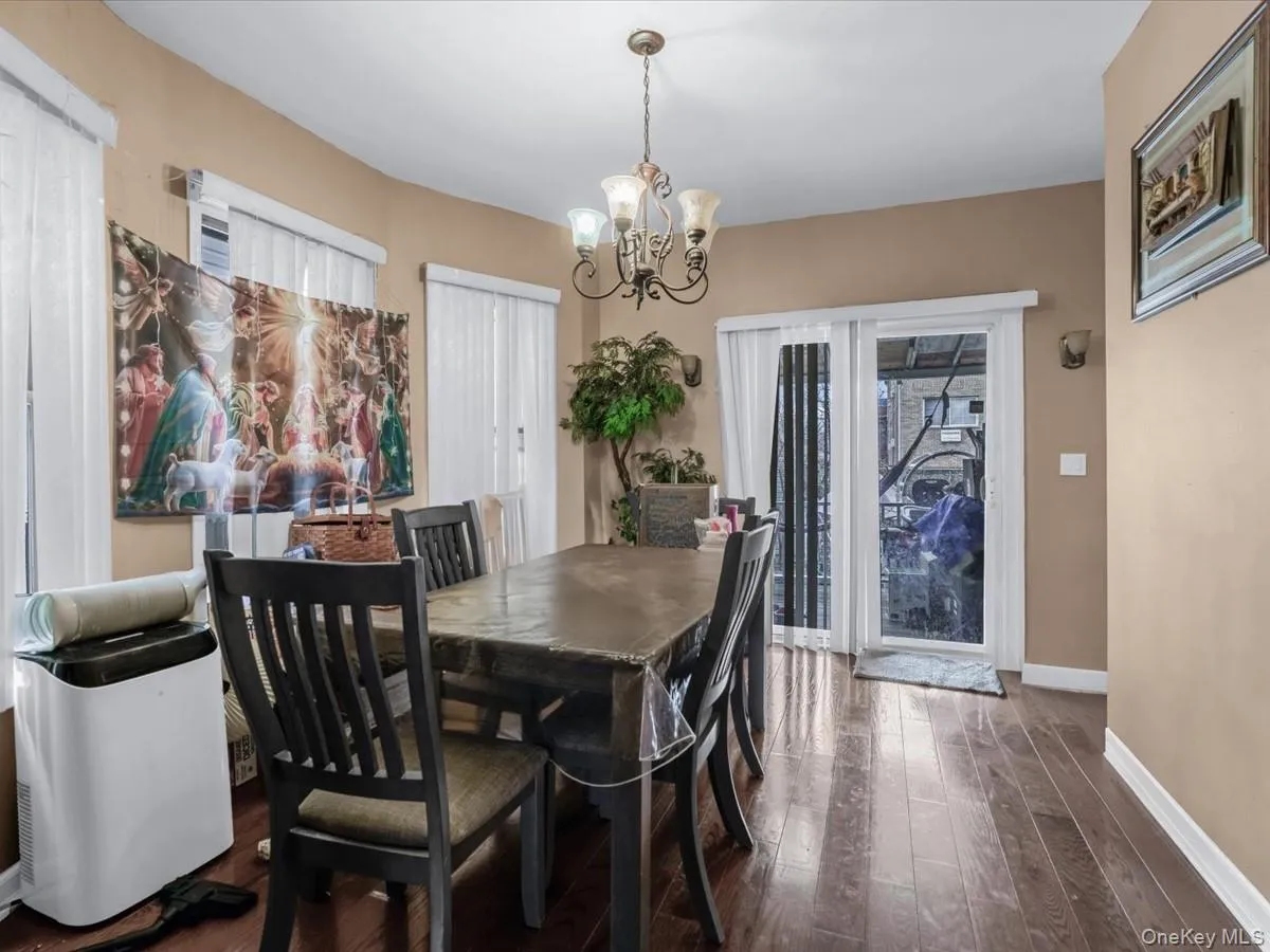 Dining area with dark wood-style floors and a chandelier Dining area with dark wood-style floors and a chandelier
