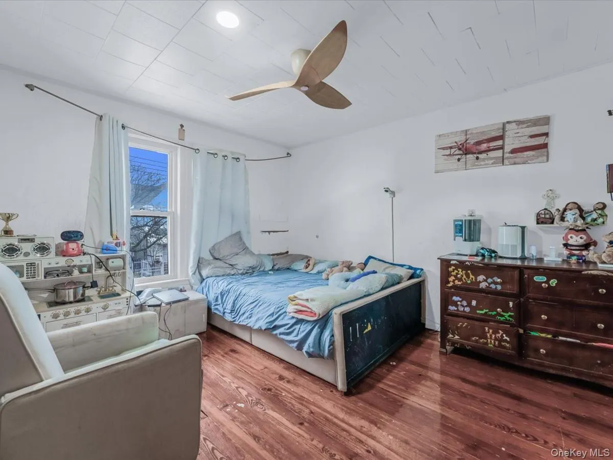 Bedroom with wood finished floors and ceiling fan Bedroom with wood finished floors and ceiling fan