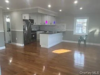 Kitchen featuring dark countertops, a peninsula, open floor plan, decorative backsplash, and recessed lighting Kitchen featuring dark countertops, a peninsula, open floor plan, decorative backsplash, and recessed lighting