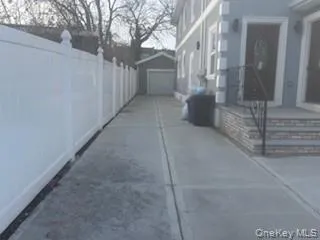 View of home's exterior featuring a garage, an outbuilding, driveway, and stucco siding View of home's exterior featuring a garage, an outbuilding, driveway, and stucco siding