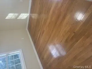 Empty room with baseboards and dark wood-type flooring Empty room with baseboards and dark wood-type flooring