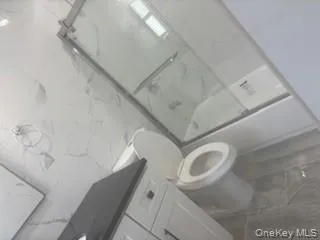 Full bathroom featuring a marble finish shower and vanity Full bathroom featuring a marble finish shower and vanity