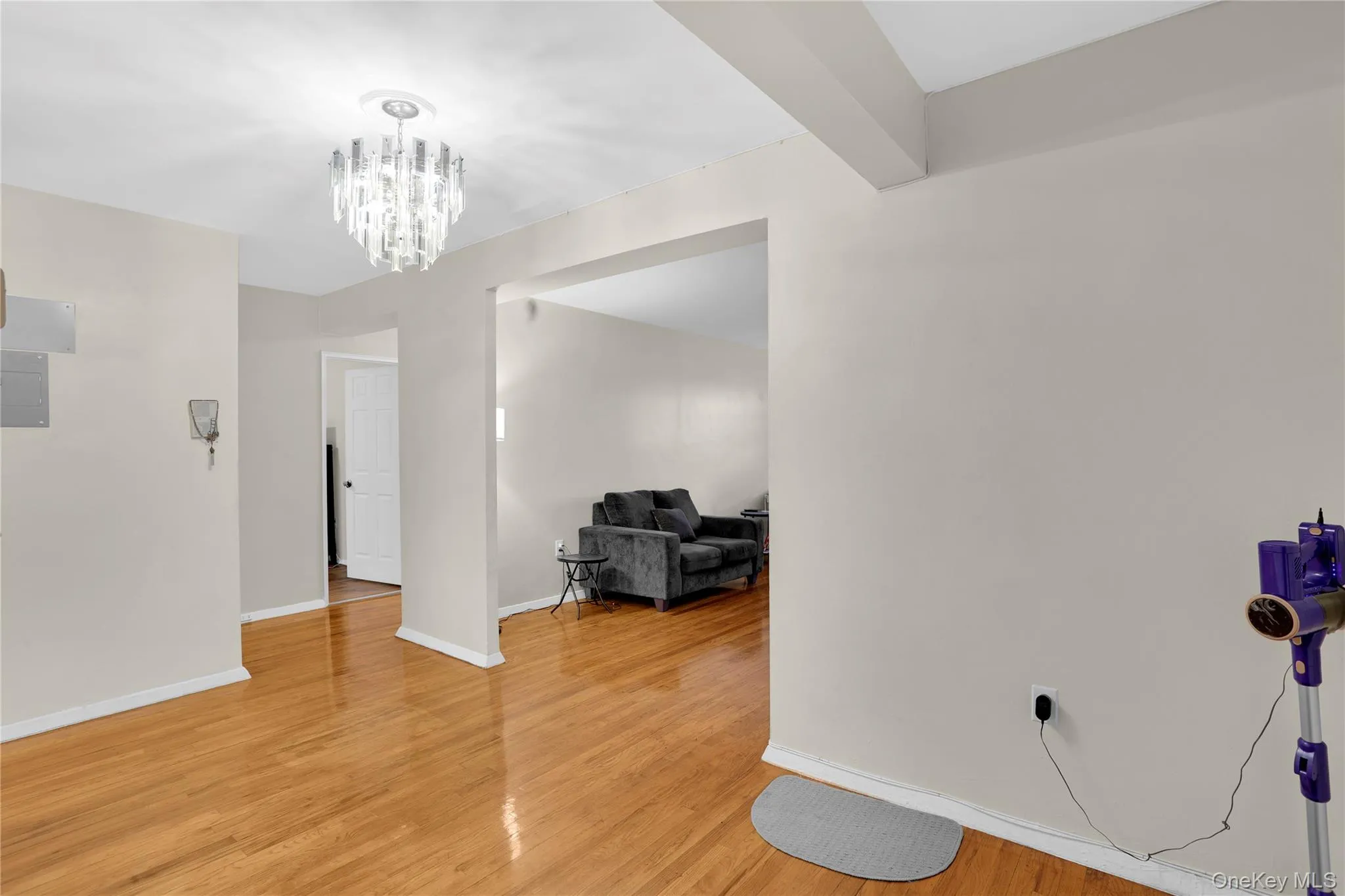Spare room with light wood-type flooring and a chandelier Spare room with light wood-type flooring and a chandelier