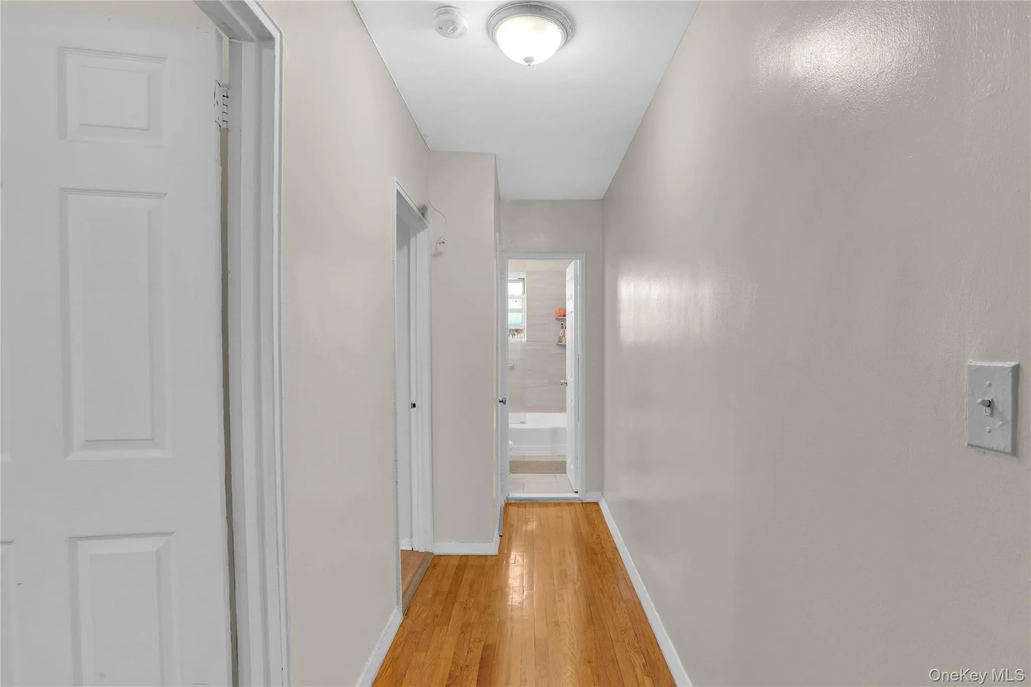 Corridor with baseboards and light wood-style flooring Corridor with baseboards and light wood-style flooring