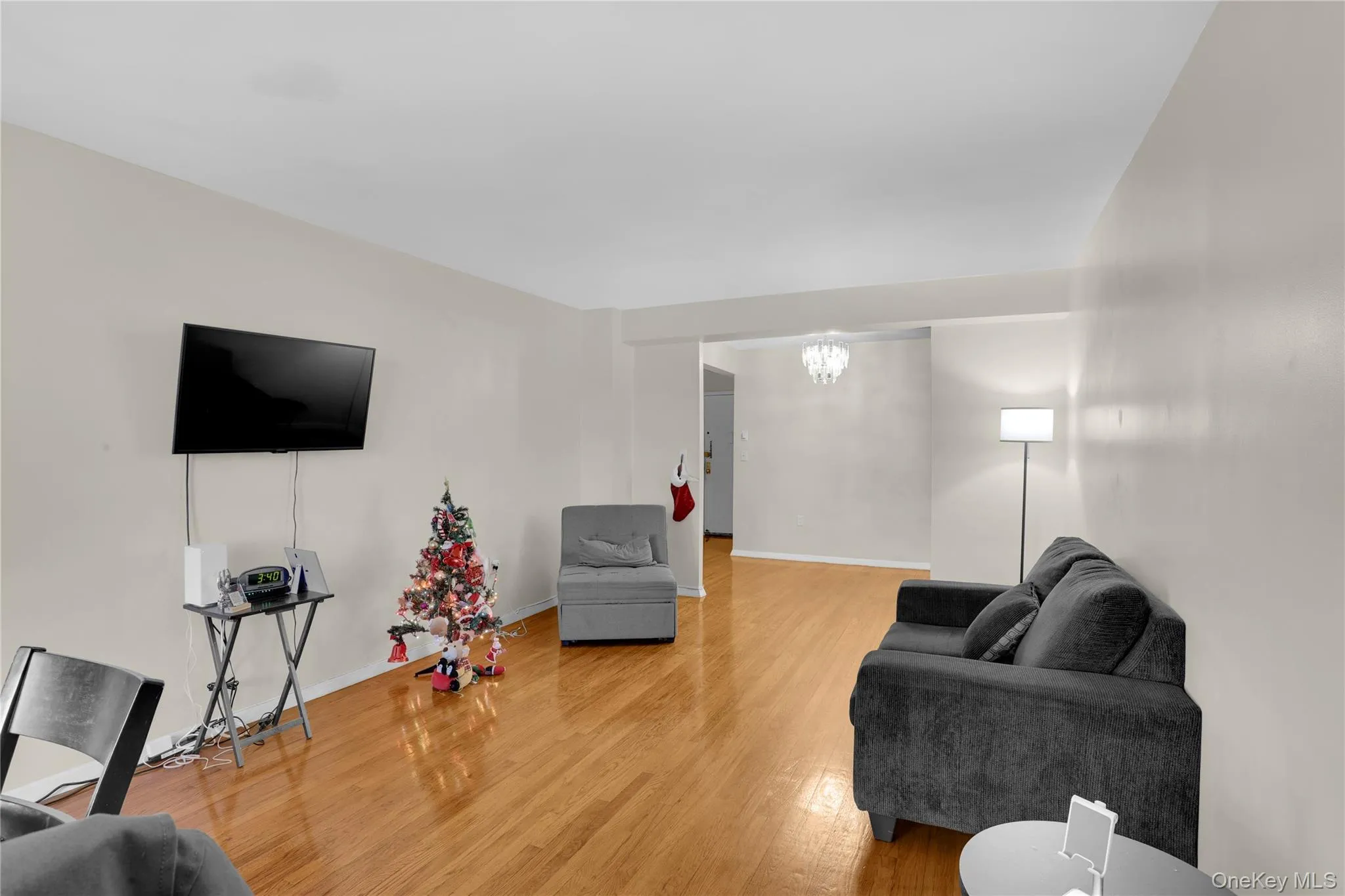 Living room with light wood-style flooring and a chandelier Living room with light wood-style flooring and a chandelier