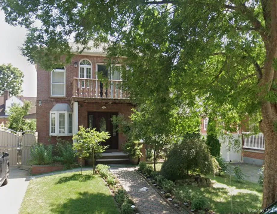 View of front of house featuring a gate, a balcony, and brick siding View of front of house featuring a gate, a balcony, and brick siding
