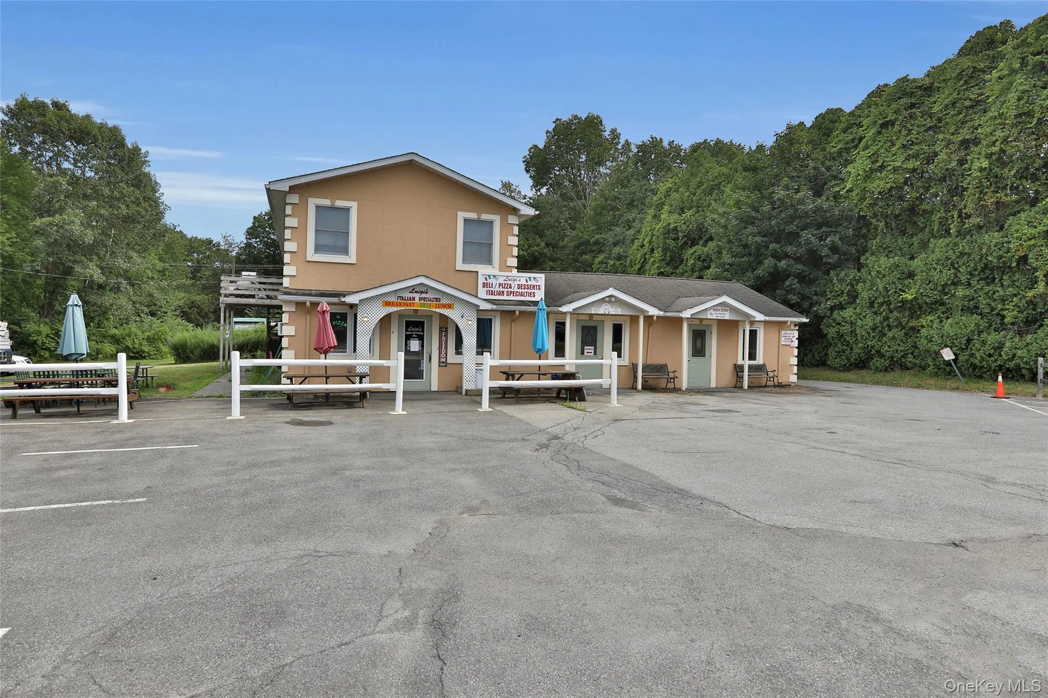 View of property featuring large parking lot. End unit for rent. View of property featuring large parking lot. End unit for rent.