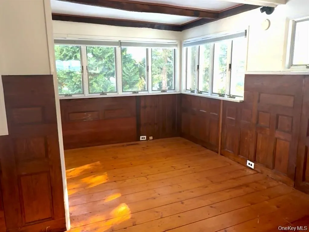 Spare room featuring light wood-style flooring and beam ceiling Spare room featuring light wood-style flooring and beam ceiling