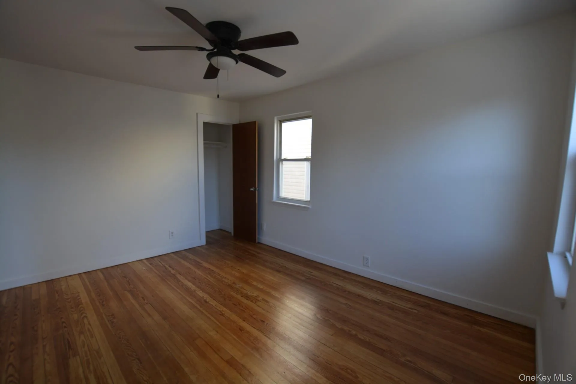Unfurnished bedroom featuring a closet, wood-type flooring, and a ceiling fan Unfurnished bedroom featuring a closet, wood-type flooring, and a ceiling fan