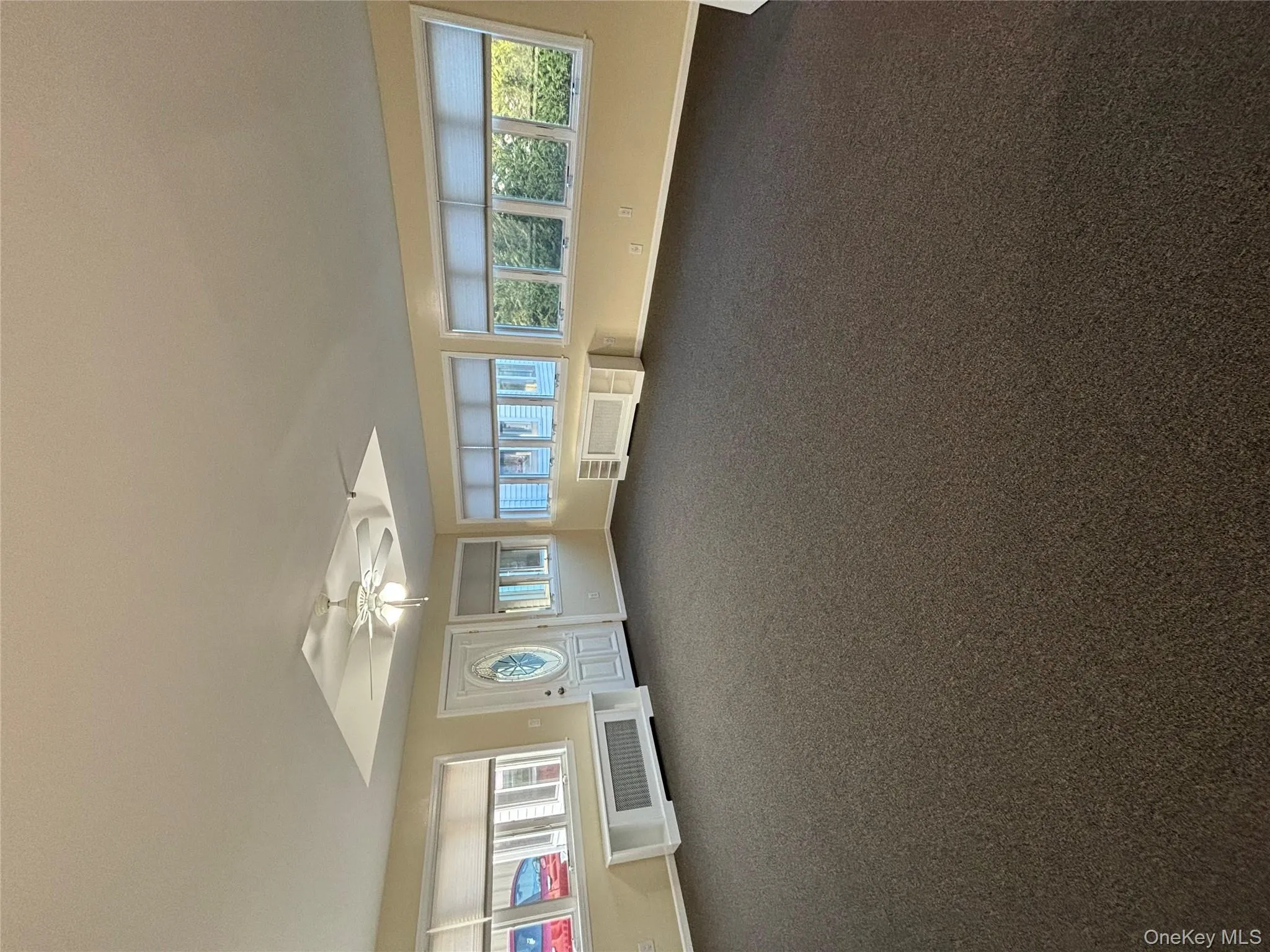 Spare room with radiator, dark carpet, and a ceiling fan Spare room with radiator, dark carpet, and a ceiling fan