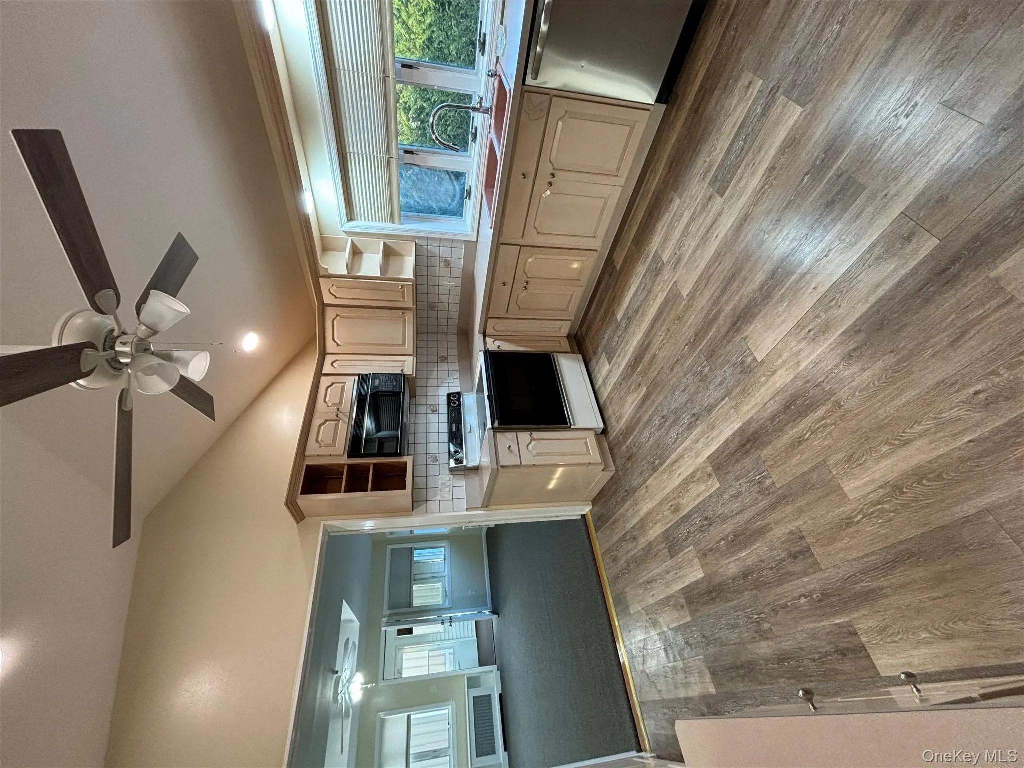 Kitchen featuring open shelves, a ceiling fan, range with electric cooktop, dishwashing machine, and light wood-style flooring Kitchen featuring open shelves, a ceiling fan, range with electric cooktop, dishwashing machine, and light wood-style flooring