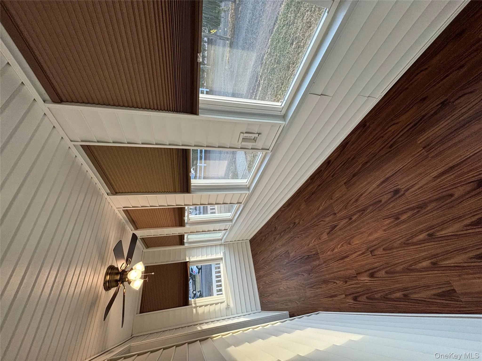 Unfurnished sunroom featuring wood ceiling, wood finished floors, and wooden walls Unfurnished sunroom featuring wood ceiling, wood finished floors, and wooden walls