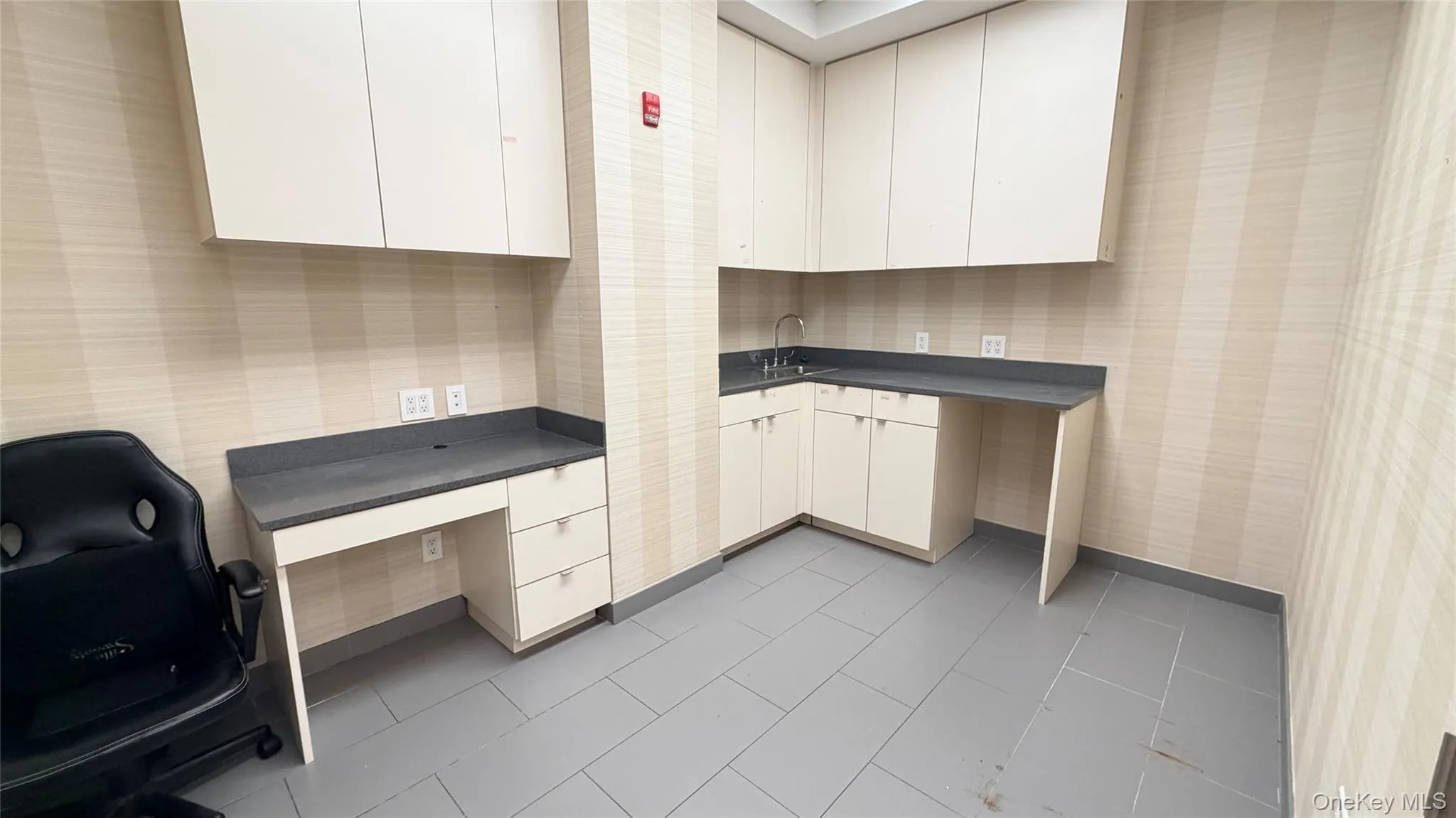 Home office with wallpapered walls and a sink Home office with wallpapered walls and a sink