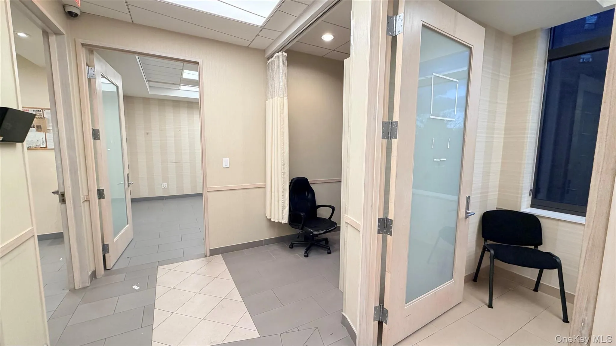Home office featuring light tile patterned floors and a drop ceiling Home office featuring light tile patterned floors and a drop ceiling