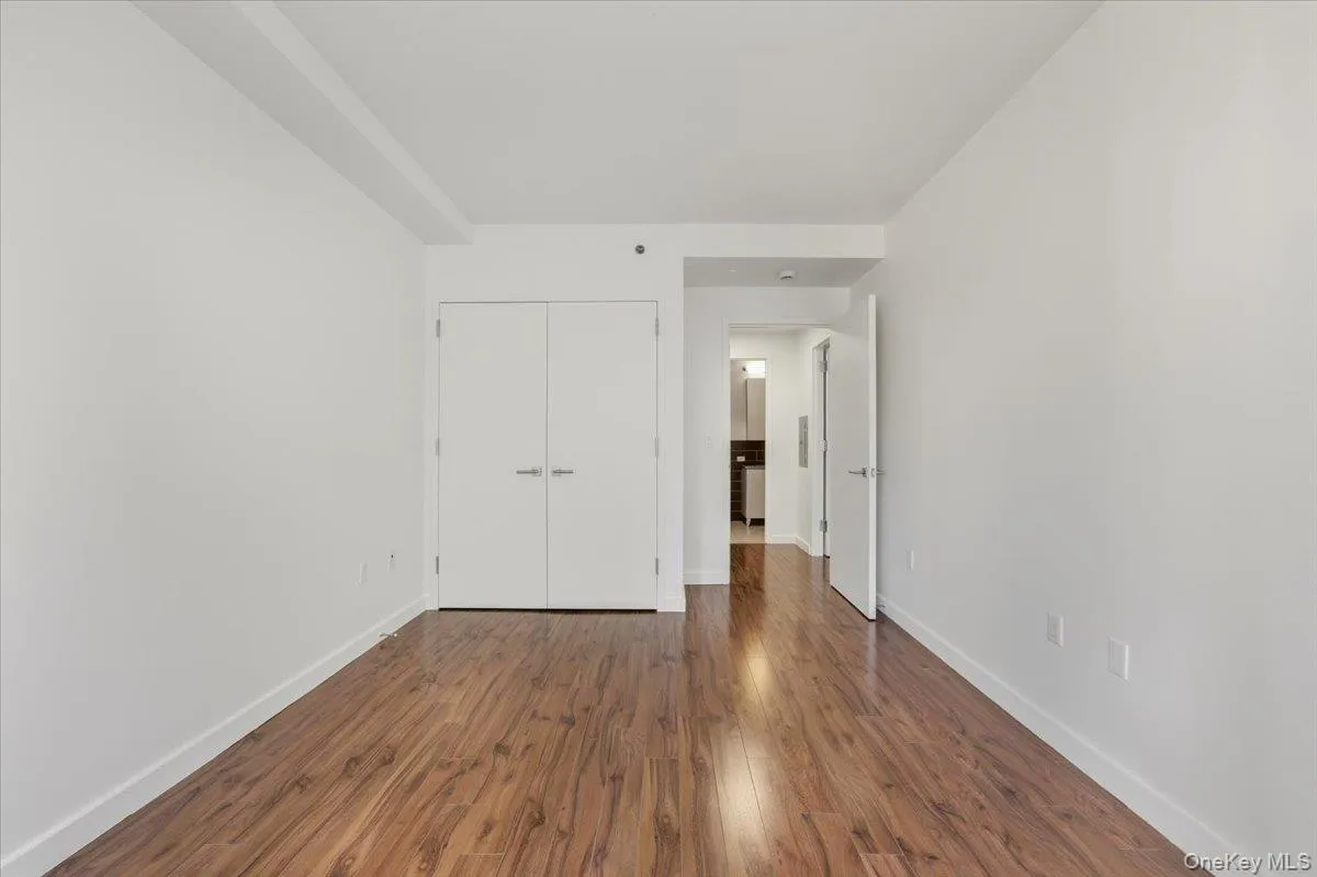 Unfurnished bedroom featuring dark wood-type flooring and a closet Unfurnished bedroom featuring dark wood-type flooring and a closet