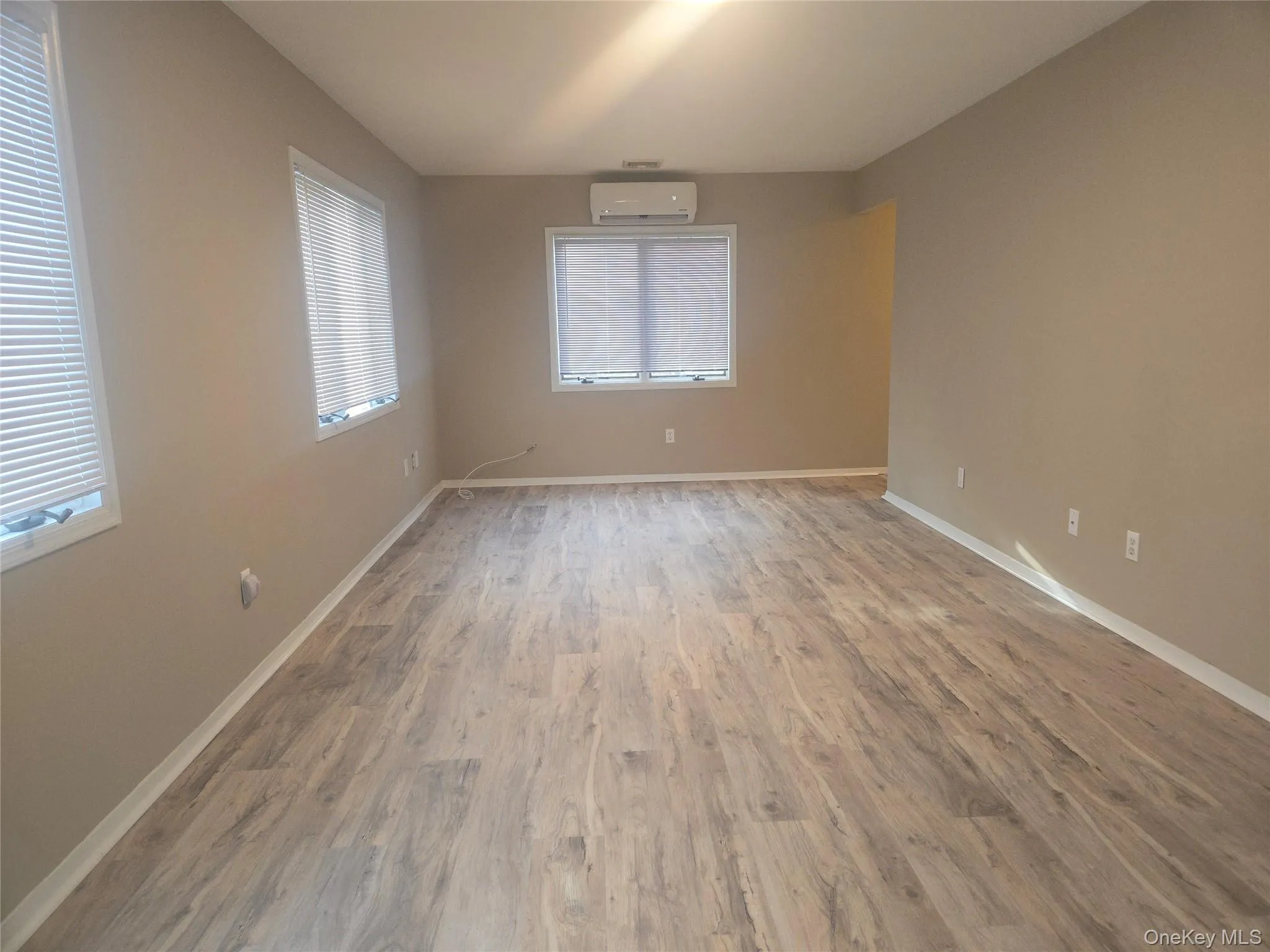 Spare room with light wood-style floors and a wall unit AC Spare room with light wood-style floors and a wall unit AC