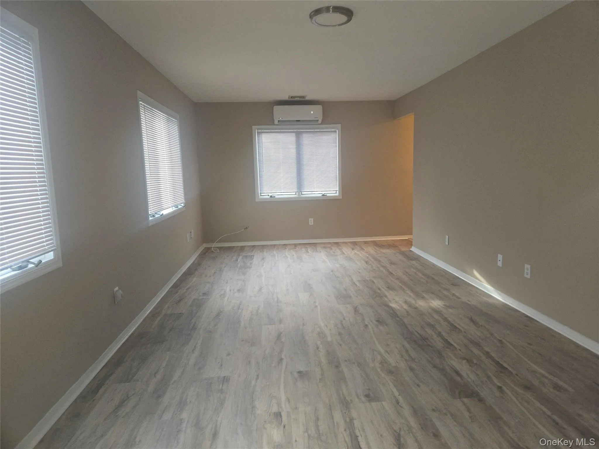 Spare room with wood finished floors and a wall mounted AC Spare room with wood finished floors and a wall mounted AC