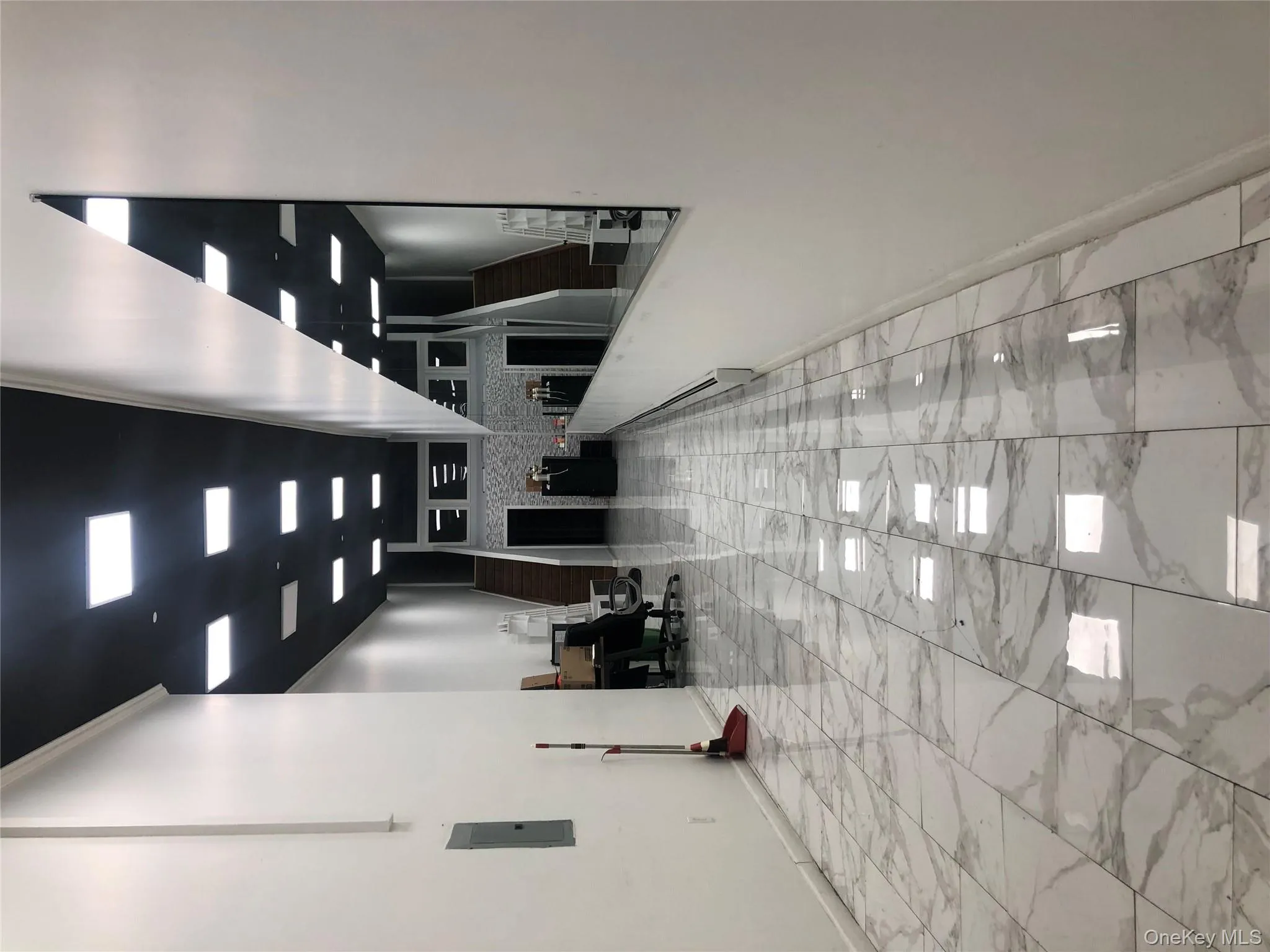 Hall featuring stairway, light marble finish flooring, and electric panel Hall featuring stairway, light marble finish flooring, and electric panel