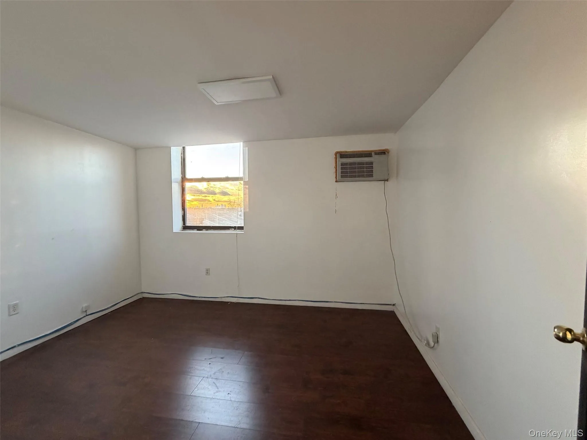 Spare room with wood finished floors and a wall unit AC Spare room with wood finished floors and a wall unit AC